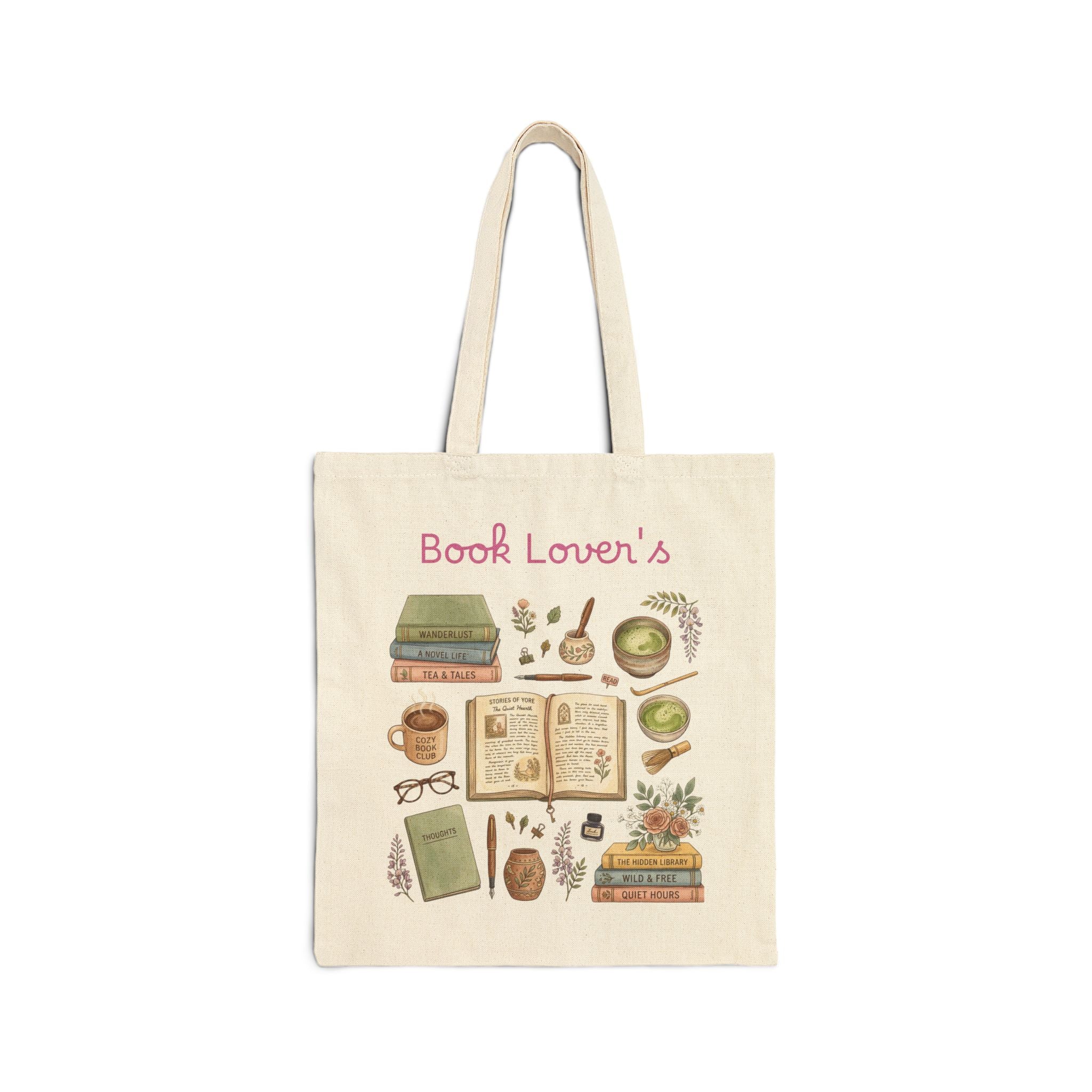 A cream canvas tote bag with a 'Book Lover's' illustration print featuring books, a mug, glasses, and botanical elements, shown on a plain white background.