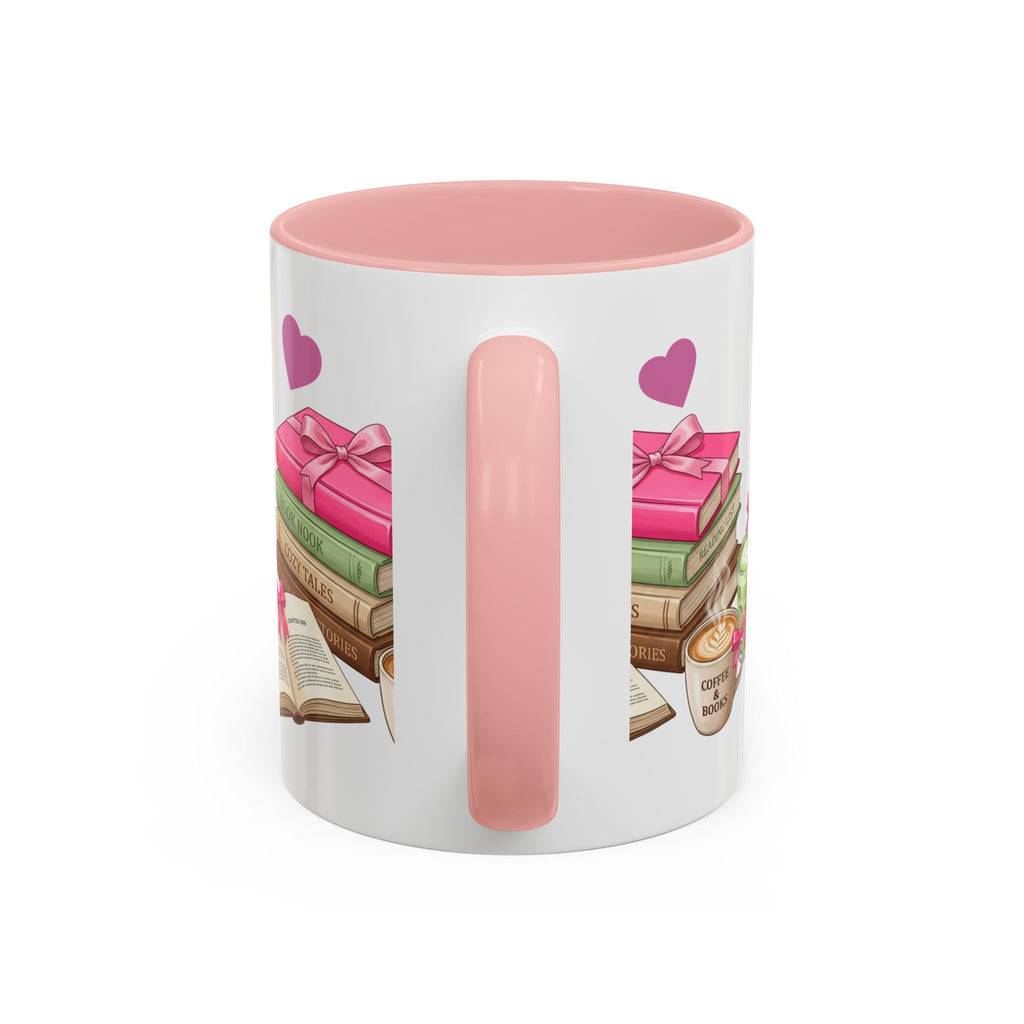 A white ceramic mug with a pink interior and handle, decorated with an illustration of stacked books, pink gift boxes, purple hearts, and a small coffee cup on the side.
