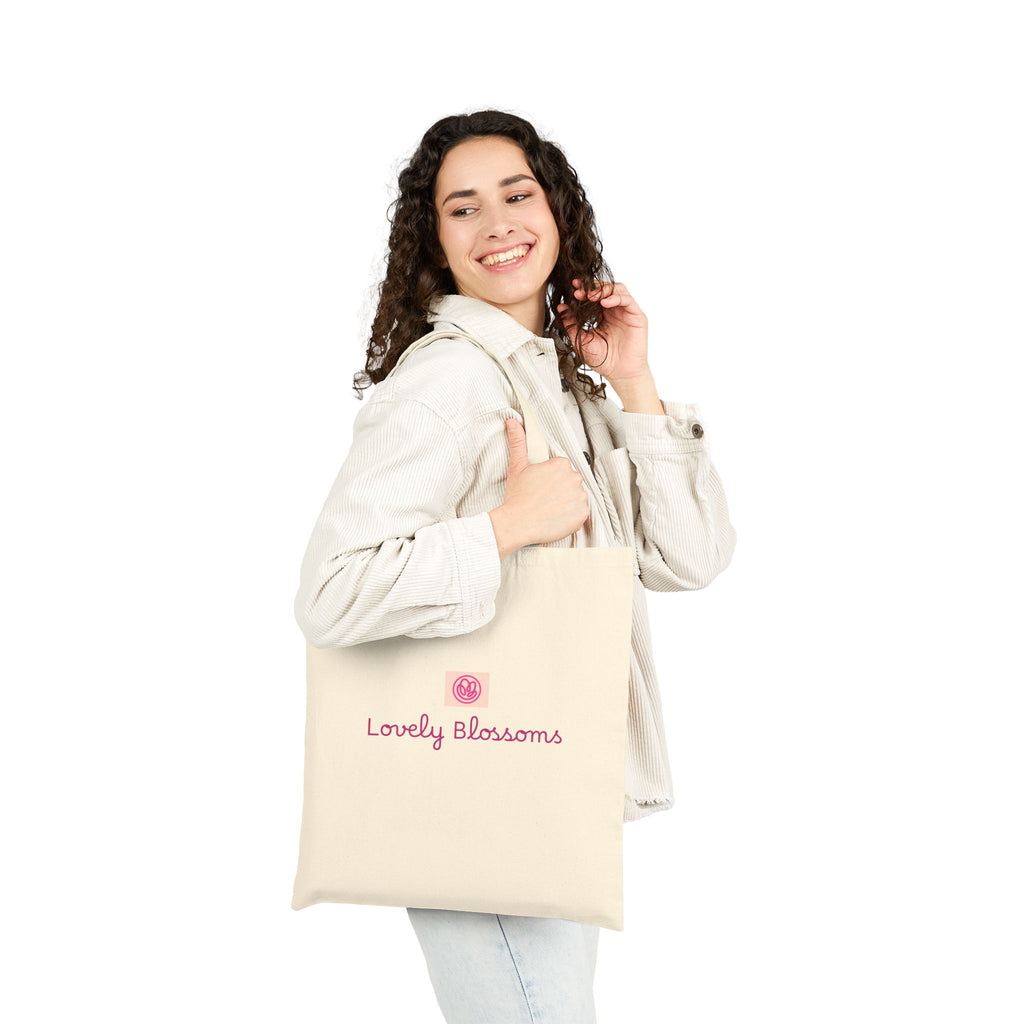 Woman holding a beige tote bag with 'ODEI' logo on a white background