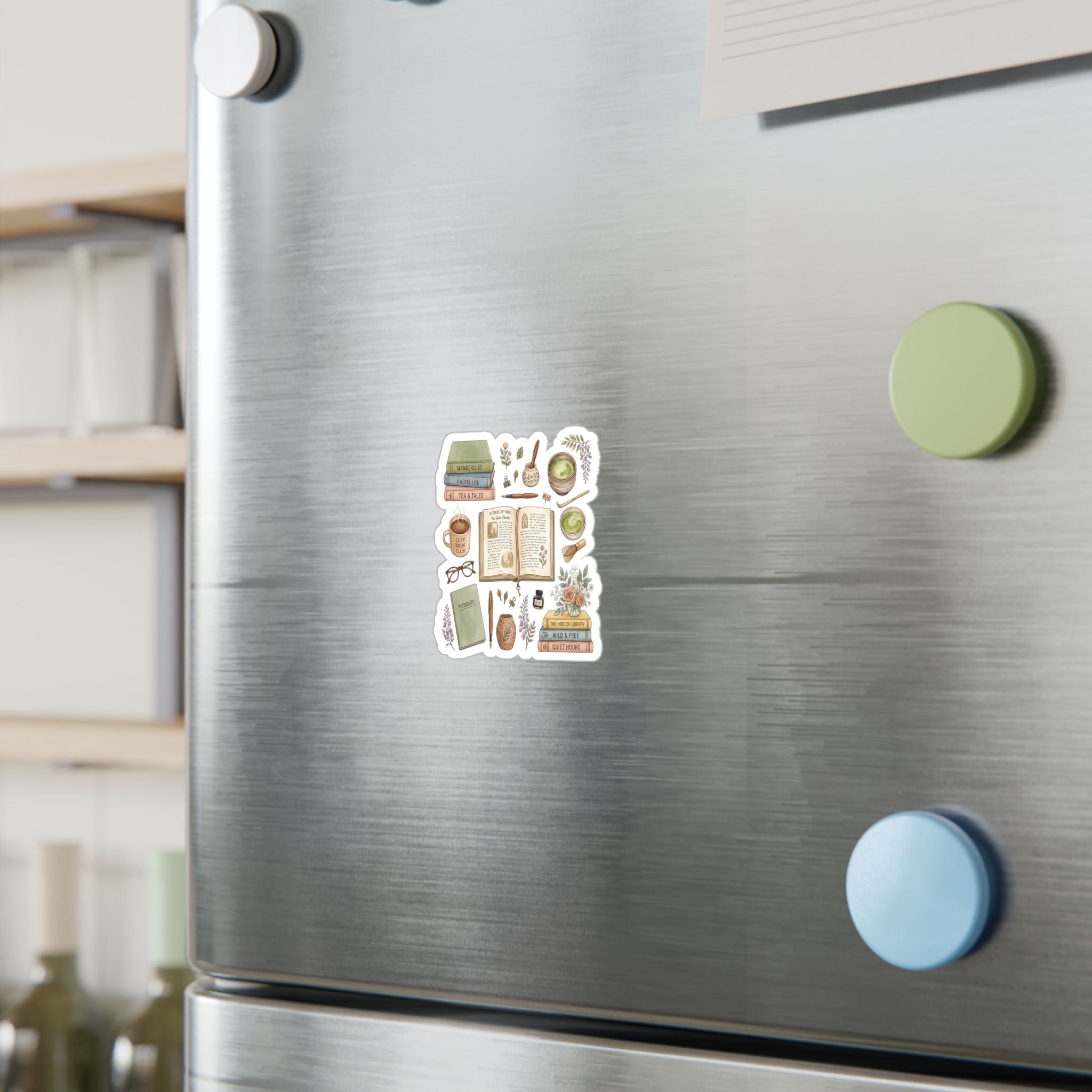 A set of twelve colorful cartoon-themed refrigerator magnets arranged in a 3x4 grid on a brushed stainless steel fridge door. The background shows a softly blurred kitchen setting with wooden shelves and other magnets on the fridge.