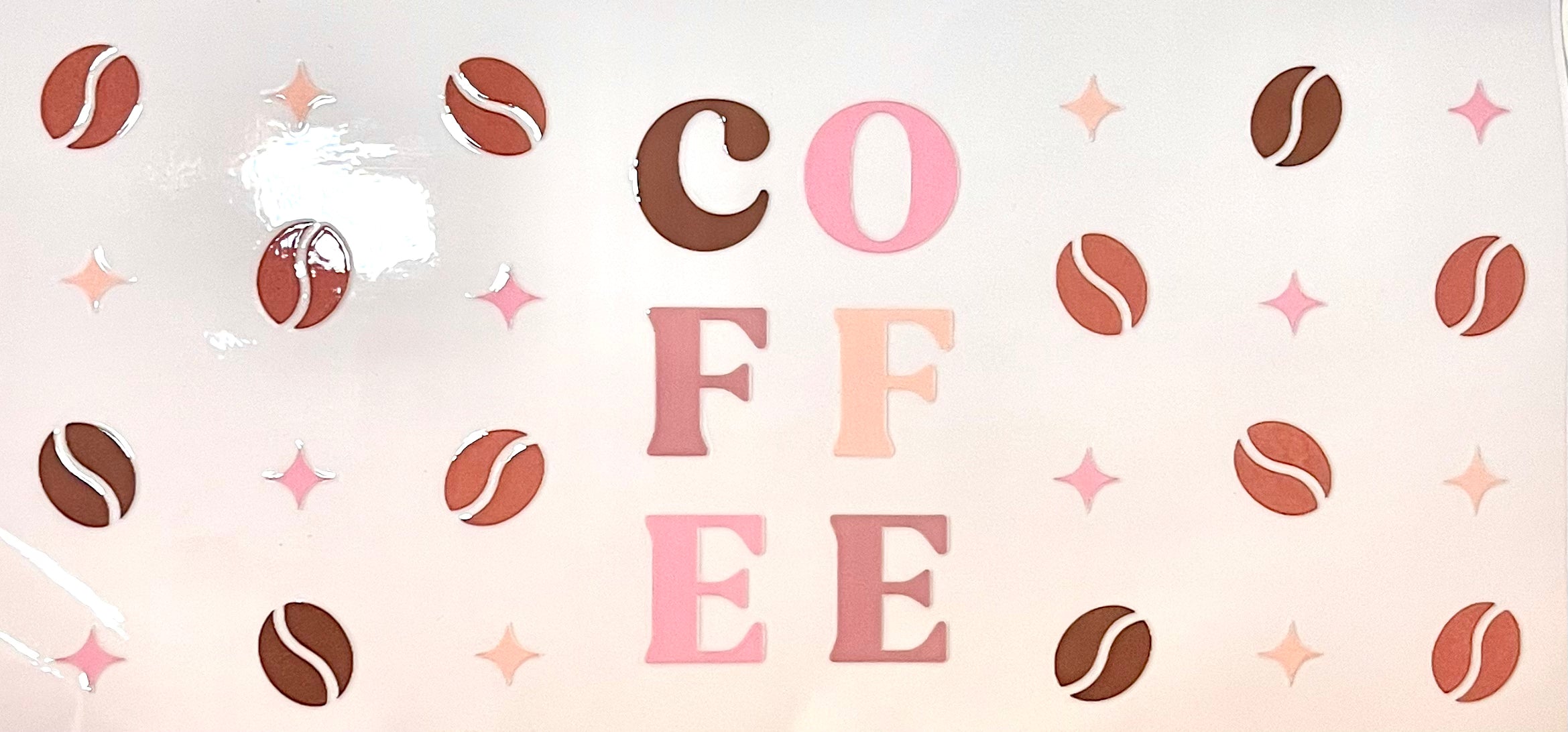 A decorative graphic with the word 'COFFEE' in large letters, surrounded by illustrated coffee beans and pink star shapes on a pale pink background.