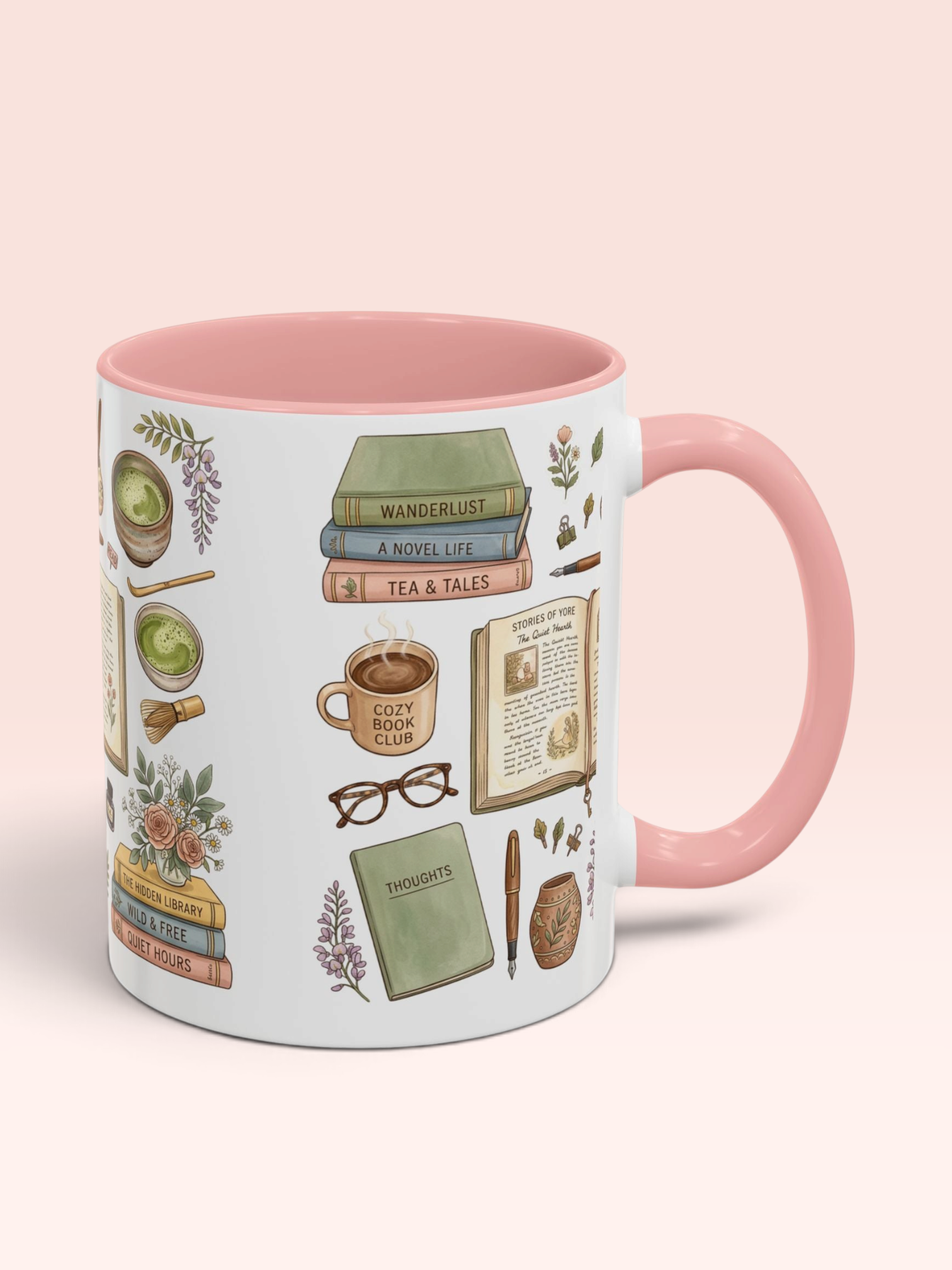 A white ceramic mug with a pink interior and handle, decorated with cozy book-themed illustrations including books, a coffee mug, glasses, and flowers, set against a solid pale pink background.
