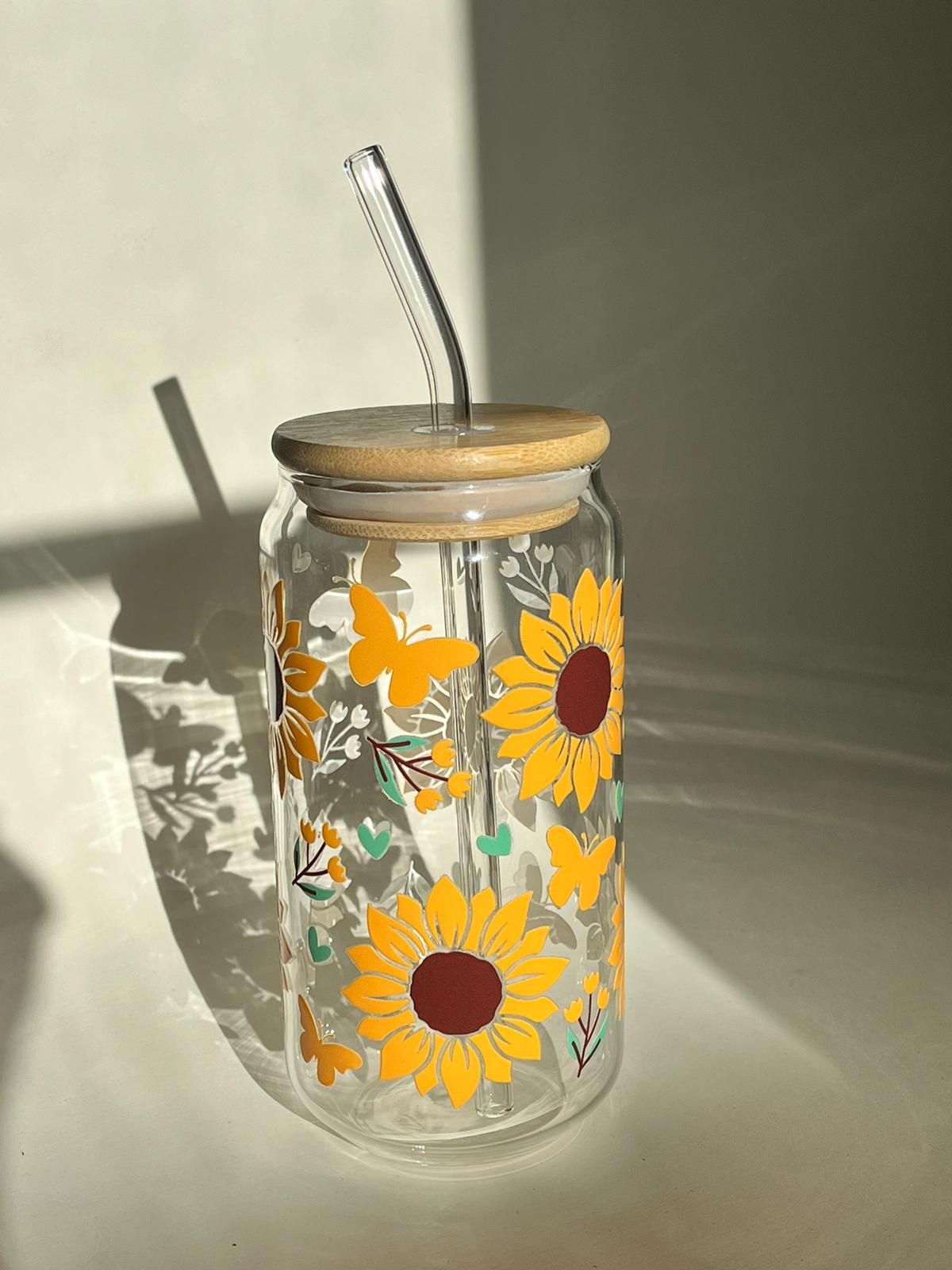 A well made glass cup decorated with bright sunflower decors with green wines.